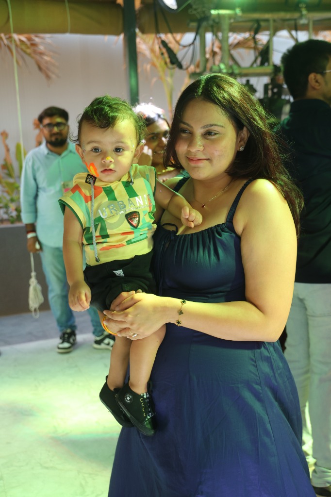 Mother holding her toddler enjoying the party